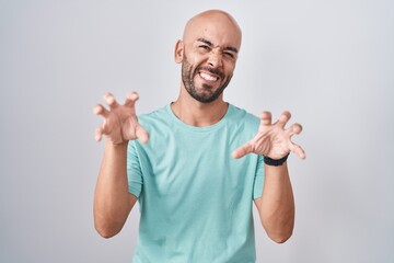 Middle age bald man standing over white background smiling funny doing claw gesture as cat, aggressive and sexy expression