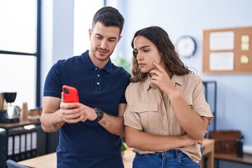 Young hispanic couple business workers using smartphone working at office