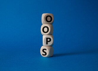 Oops symbol. Concept word Oops on wooden cubes. Beautiful blue background. Business and Oops concept. Copy space.