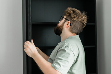 Fototapeta premium Portrait of man assembling furniture. Do it yourself furniture assembly at home