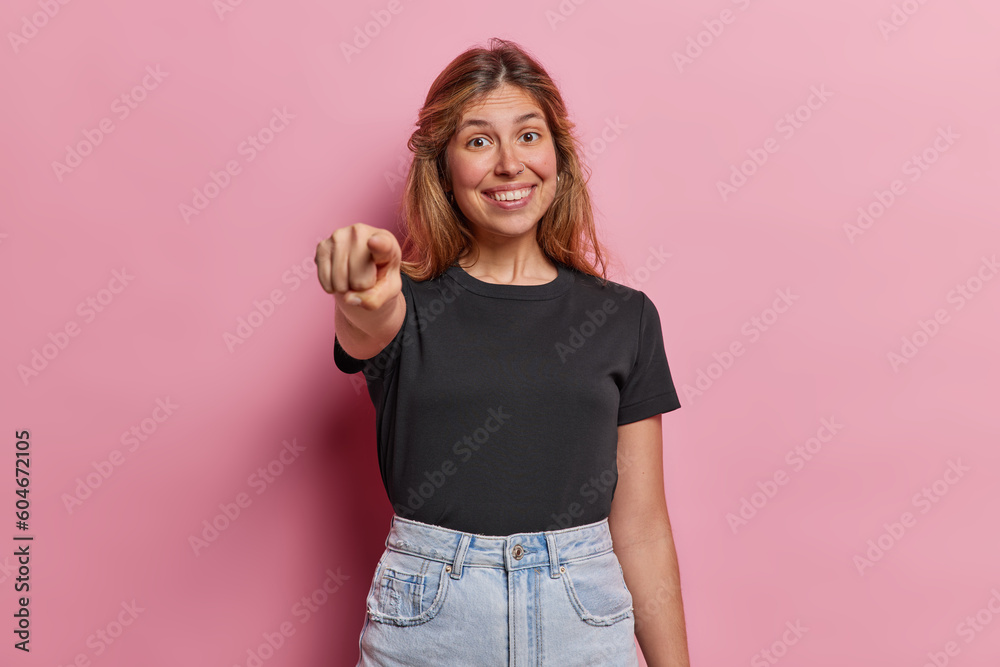 Wall mural studio shot of good looking cheerful woman with piercing in nose dressed in casual black t shirt and