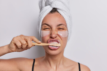 Photo of young woman brushes teeth with toothpaste holds toothbrush applies hydrogel patches under...