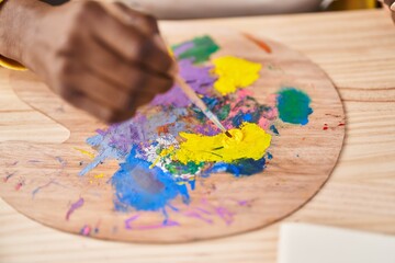 African american woman artist mixing color at art studio