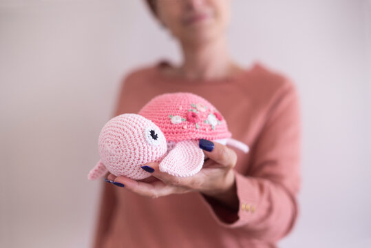 Woman holding a homemade crochet turtle (Amigurumi)