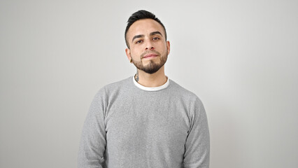 Hispanic man standing with serious expression over isolated white background