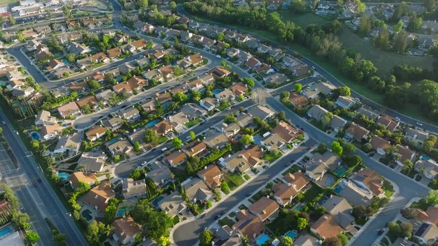 Suburban housing district area in USA. American homes in quiet neighborhood at golden hour. Beautiful green suburb aerial at scenic sunset 4K California. Aerial drone shot of residential Los Angeles