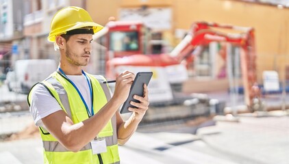 Young hispanic man architect drawing on touchpad at park