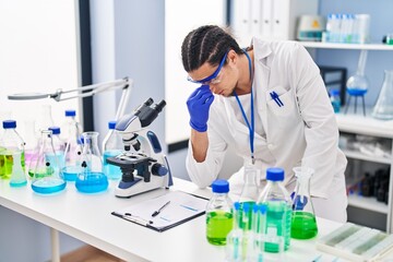 Young man wearing scientist uniform stressed working at laboratory