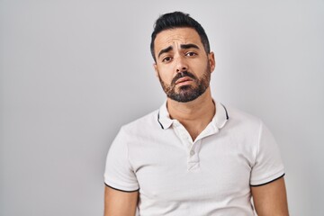 Young hispanic man with beard wearing casual clothes over white background looking sleepy and tired, exhausted for fatigue and hangover, lazy eyes in the morning.