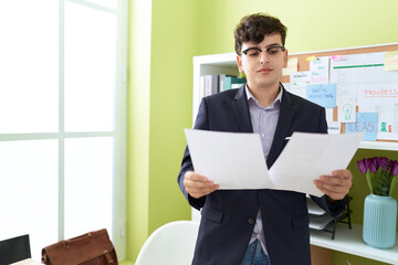 Non binary man business worker reading document at office