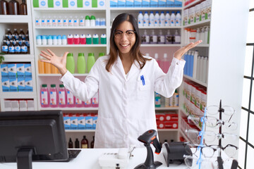 Middle age chinese woman working at pharmacy drugstore celebrating victory with happy smile and winner expression with raised hands