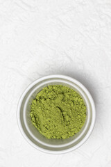 Matcha green tea powder in a bowl.