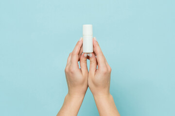 Bottle of eye drops (nasal spray) in woman's hand. Copy space