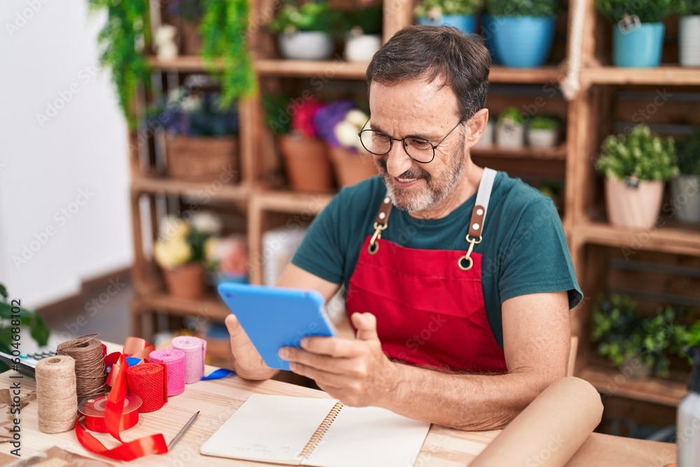 Sticker middle age man florist smiling confident using touchpad at florist