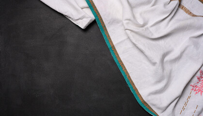 Folded  linen kitchen towel on a black background, top view. Copy space