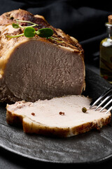 Baked piece of pork balyk on the table with spices. Tenderloin cut into pieces