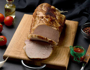 Baked piece of pork balyk on the table with spices. Tenderloin cut into pieces