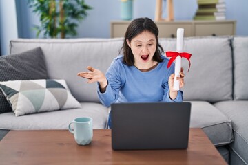 Woman with down syndrome holding graduate degree diploma doing video call celebrating achievement...