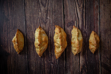 Little pastries with apples on dark wooden background 