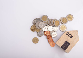 Money and house model laying on white background