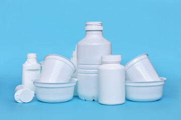 Different plastic waste packages on blue background