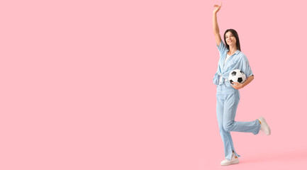 Fototapeta na wymiar Happy young woman with soccer ball on pink background with space for text