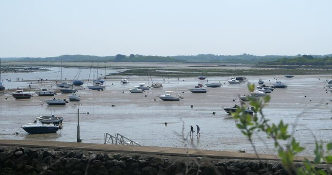 A panorama of a coastal landscape with some small boats at low tide in front of the village of Kercabellec. Mesquer, France, May 2023.