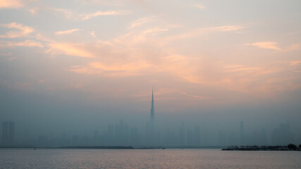 Sunset over the skyscrapers and the Skyline of Dubai (UAE - United Arab Emirates) during a foggy day.