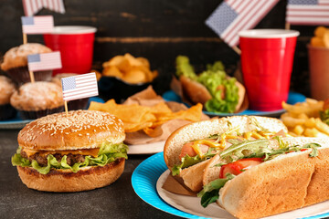 Tasty dishes and drinks for Memorial Day celebration on dark table, closeup