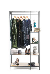 Shelving unit with dresses, shoes and accessories on white background