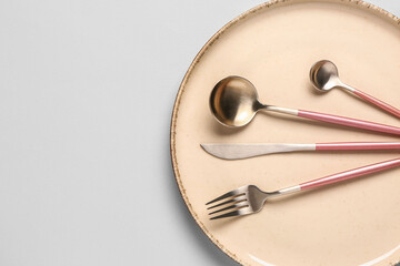 Table setting with clean plate and cutlery on grey background