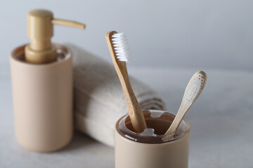 Holder of bamboo toothbrushes and bath accessories on white table