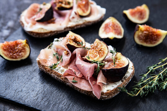 Tasty bruschetta with cream cheese, proscuitto  and figs