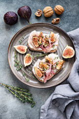 Toasts with cream cheese, figs and  ham  on the table