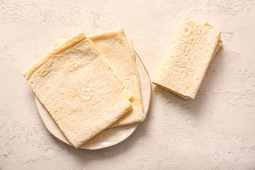Plate with fresh lavash on light background