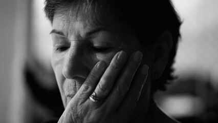 Preoccupied senior woman feeling worry and loneliness in monochrome black and white. Thoughtful pensive expression of an older person in contemplation