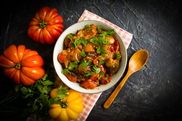 Sauteed eggplant and tomato on old background