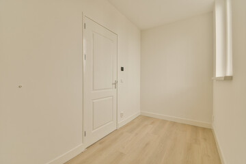 Fototapeta na wymiar an empty room with white walls and wood flooring the door is in front of the wall to the right