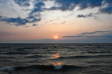 Sun over Lake Erie with clouds in sky and white cap waves