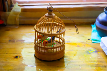 wooden cage with artifical birds on the table