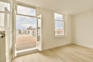Fototapeta premium an empty room with wood floors and white walls, looking out onto the street from inside one of the rooms