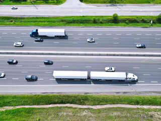 Aerial view of truck trailers and cars driving on busy Ontario highway 401 near Toronto.