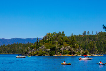 Fototapeta na wymiar View of Fannette Island, boaters and kayakers in Emerald Bay, Lake Tahoe California from the shore