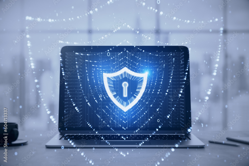 Poster close up of laptop on desk with coffee cup and glowing polygonal web security shield hologram on blu