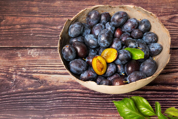 A rustic bowl full of freshly harvested plums