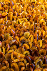 halved fresh plums lined up on plum cake sheet cake