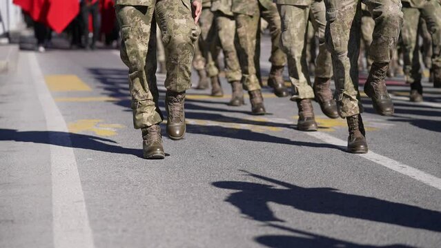 Soldiers marching with military clothes in cadence at an army parade on road