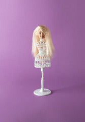 Head of girl doll on white stand for doll. Minimal concept.