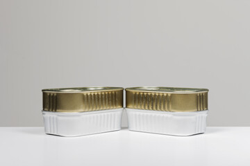 A stack of various metal canning tins on a plain