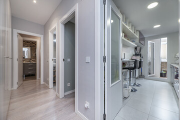 A hall of a residential house with access doors to several rooms